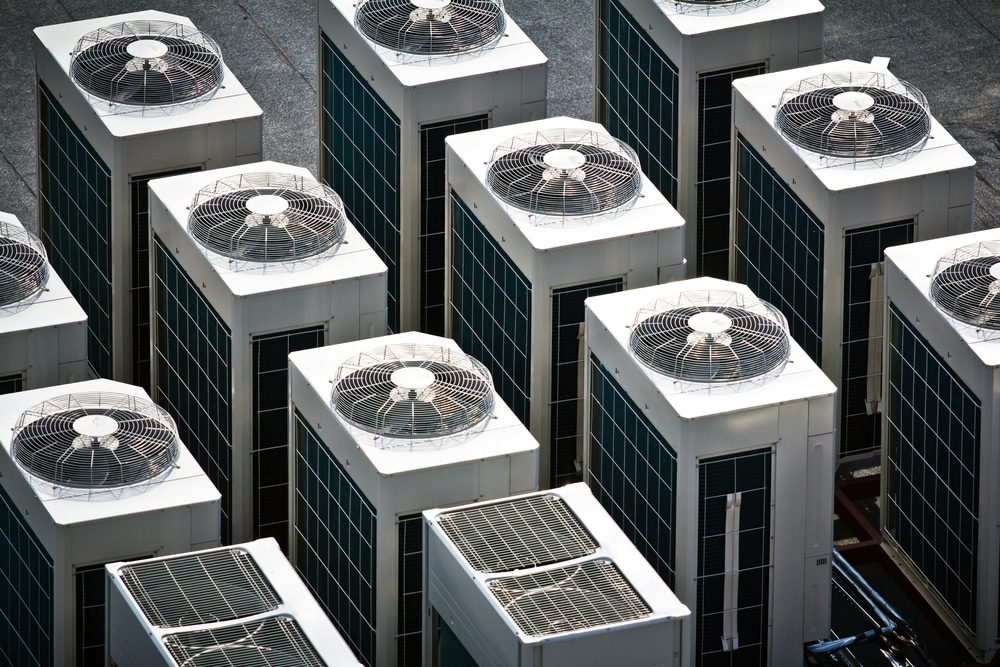 several air conditioners on the roof of a large building